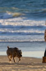 CHARLIZE THERON Walking on the Beach at Sunset