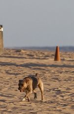 CHARLIZE THERON Walking on the Beach at Sunset