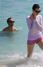 ANNE HATHAWAY in a Covered Bikini on the Beach in Miami