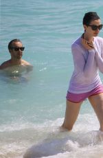 ANNE HATHAWAY in a Covered Bikini on the Beach in Miami