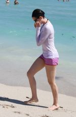 ANNE HATHAWAY in a Covered Bikini on the Beach in Miami