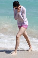 ANNE HATHAWAY in a Covered Bikini on the Beach in Miami
