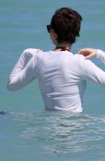 ANNE HATHAWAY in a Covered Bikini on the Beach in Miami