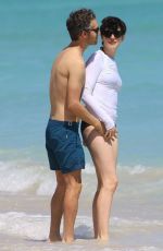 ANNE HATHAWAY in a Covered Bikini on the Beach in Miami