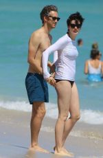 ANNE HATHAWAY in a Covered Bikini on the Beach in Miami
