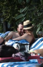 KATIE CASSIDY in Bikini Sunbathing at a Pool in Miami