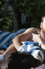 KATIE CASSIDY in Bikini Sunbathing at a Pool in Miami