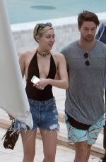 MILEY CYRUS and Patrick Schwarzenegger at a Pool in Miami