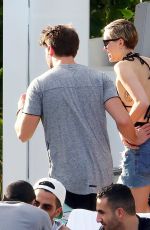 MILEY CYRUS and Patrick Schwarzenegger at a Pool in Miami