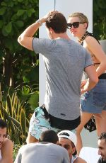 MILEY CYRUS and Patrick Schwarzenegger at a Pool in Miami