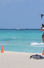 CLAUDIA ROMANI in Bikini Playing with a Dron on the Beach in Miami