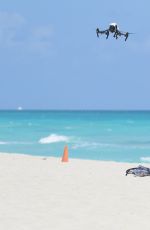 CLAUDIA ROMANI in Bikini Playing with a Dron on the Beach in Miami