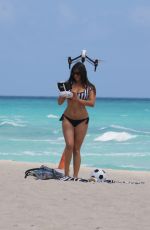 CLAUDIA ROMANI in Bikini Playing with a Dron on the Beach in Miami