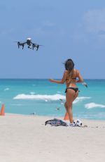 CLAUDIA ROMANI in Bikini Playing with a Dron on the Beach in Miami