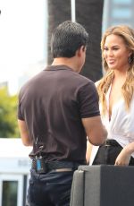CHRISSY TEIGEN on the Set of Extra in Los Angeles