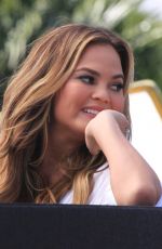 CHRISSY TEIGEN on the Set of Extra in Los Angeles