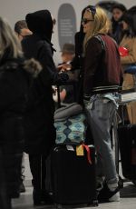 CARA DELEVINGNE and ANNIE CLARK at Charles-De-Gaulle Airport in Paris 02/28/2016
