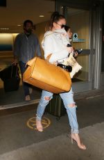 CHRISSY TEIGEN in Ripped Jeans at LAX Airport in Los Angeles 04/13/2017