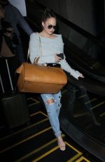 CHRISSY TEIGEN in Ripped Jeans at LAX Airport in Los Angeles 04/13/2017