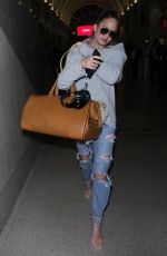 CHRISSY TEIGEN in Ripped Jeans at LAX Airport in Los Angeles 04/13/2017