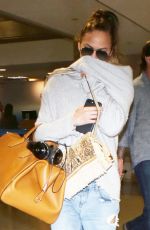 CHRISSY TEIGEN in Ripped Jeans at LAX Airport in Los Angeles 04/13/2017