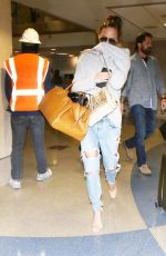 CHRISSY TEIGEN in Ripped Jeans at LAX Airport in Los Angeles 04/13/2017