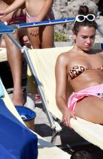 DUA LIPA Sunbathing at a Beach in Capri 08/29/2017