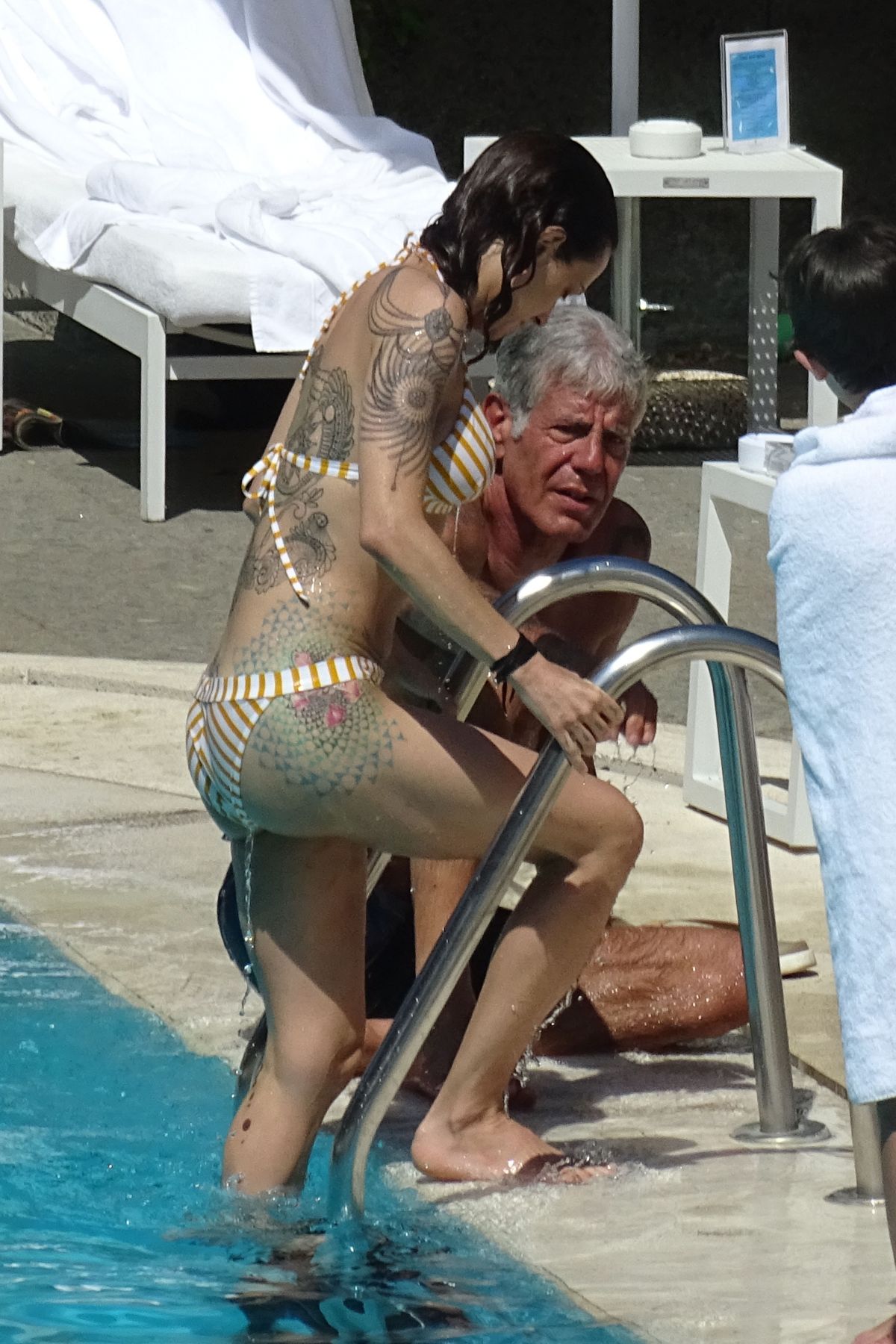 ASIA ARGENTO in Bikini and Anthony Bourdain at a Pool in Rome 09/20/2017.