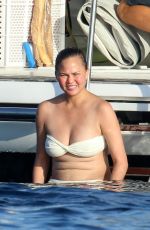 CHRISSY TEIGEN in Bikini at a Boat in Sardinia 08/30/2017