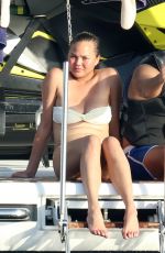 CHRISSY TEIGEN in Bikini at a Boat in Sardinia 08/30/2017