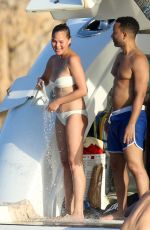 CHRISSY TEIGEN in Bikini at a Boat in Sardinia 08/30/2017