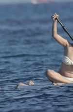 CHRISSY TEIGEN Paddleboarding in Sardinia 08/30/2017