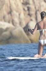 CHRISSY TEIGEN Paddleboarding in Sardinia 08/30/2017