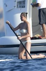 CHRISSY TEIGEN Paddleboarding in Sardinia 08/30/2017