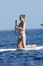 CHRISSY TEIGEN Paddleboarding in Sardinia 08/30/2017