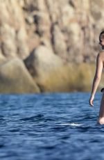 CHRISSY TEIGEN Paddleboarding in Sardinia 08/30/2017