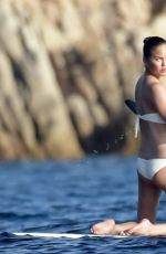 CHRISSY TEIGEN Paddleboarding in Sardinia 08/30/2017