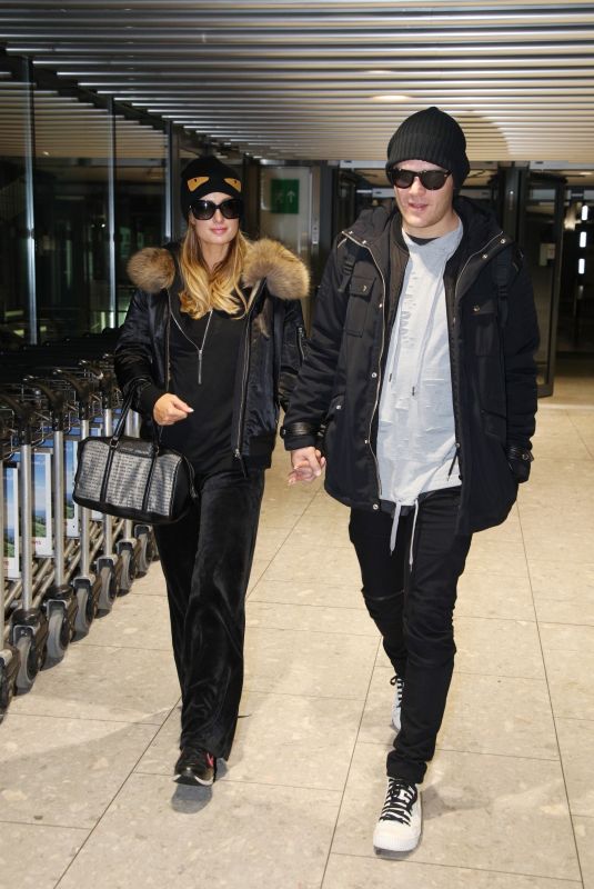 PARIS HILTON and Chris Zylka at Heathrow Airport in London 12/20/2017