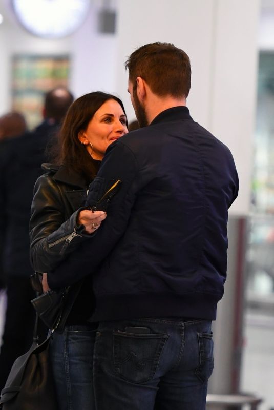 COURTENEY COX and Johnny McDaid at Heathrow Airport in London 02/17/2018