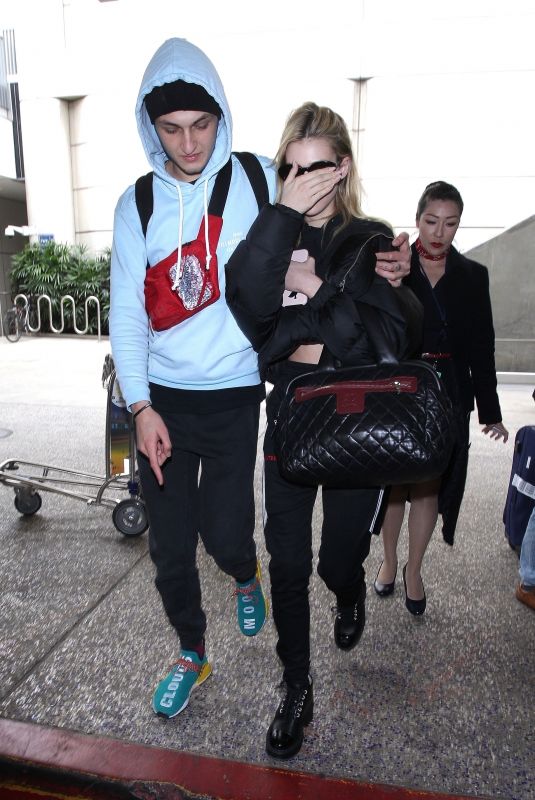 NICOLA PELTZ and Anwar Hadid at LAX Airport in Los Angeles 03/07/2018