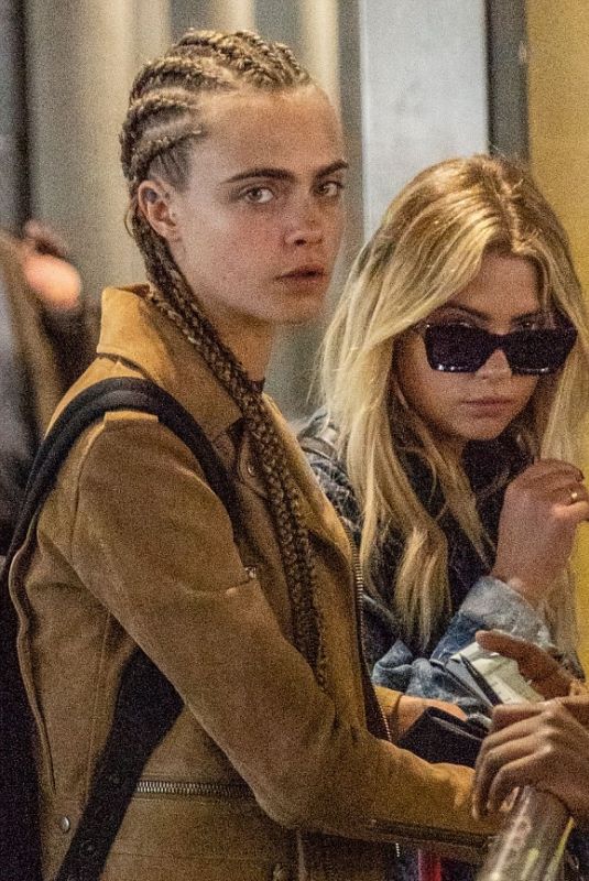 CARA DELEVINGNE and ASHLEY BENSON at Heathrow Airport in London 08/13/2018