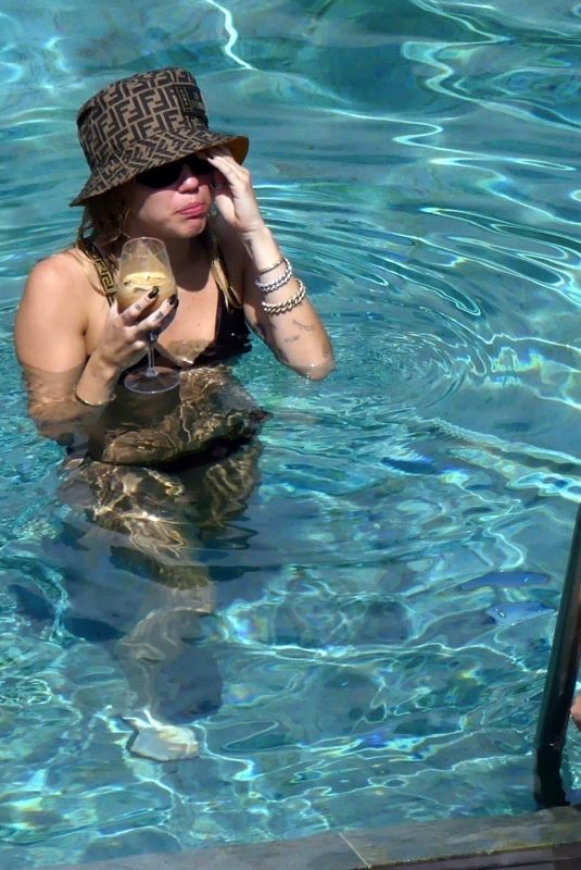 MILEY CYRUS and KAITLYNN CARTER in Bikinis at a Pool in Italy 08/11/2019