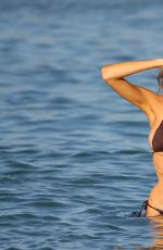 CHARLOTTE MCKINNEY in a Black Bikini on the Beach in Miami 12/21/2020