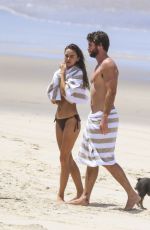 GABRIELLA BROOKS in Bikini and Liam Hemsworth at a Beach in Byron Bay 02/24/2021