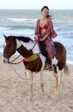 ALESSANDRA AMBROSIO in a Red Bikini Riding a Horse at a Beach in Trancoso 08/05/2021