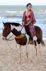 ALESSANDRA AMBROSIO in a Red Bikini Riding a Horse at a Beach in Trancoso 08/05/2021