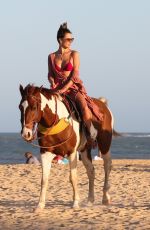 ALESSANDRA AMBROSIO in a Red Bikini Riding a Horse at a Beach in Trancoso 08/05/2021