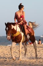 ALESSANDRA AMBROSIO in a Red Bikini Riding a Horse at a Beach in Trancoso 08/05/2021