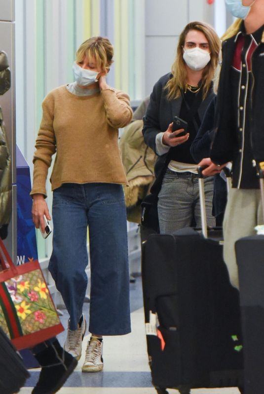 SIENNA MILLER and CARA DELEVINGNE at JFK Airport in New York 12/30/2021