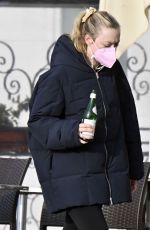 DAKOTA FANNING Holding a Bottle of Wine Out in Venice 01/22/2022